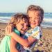 Children hug cuddle beach