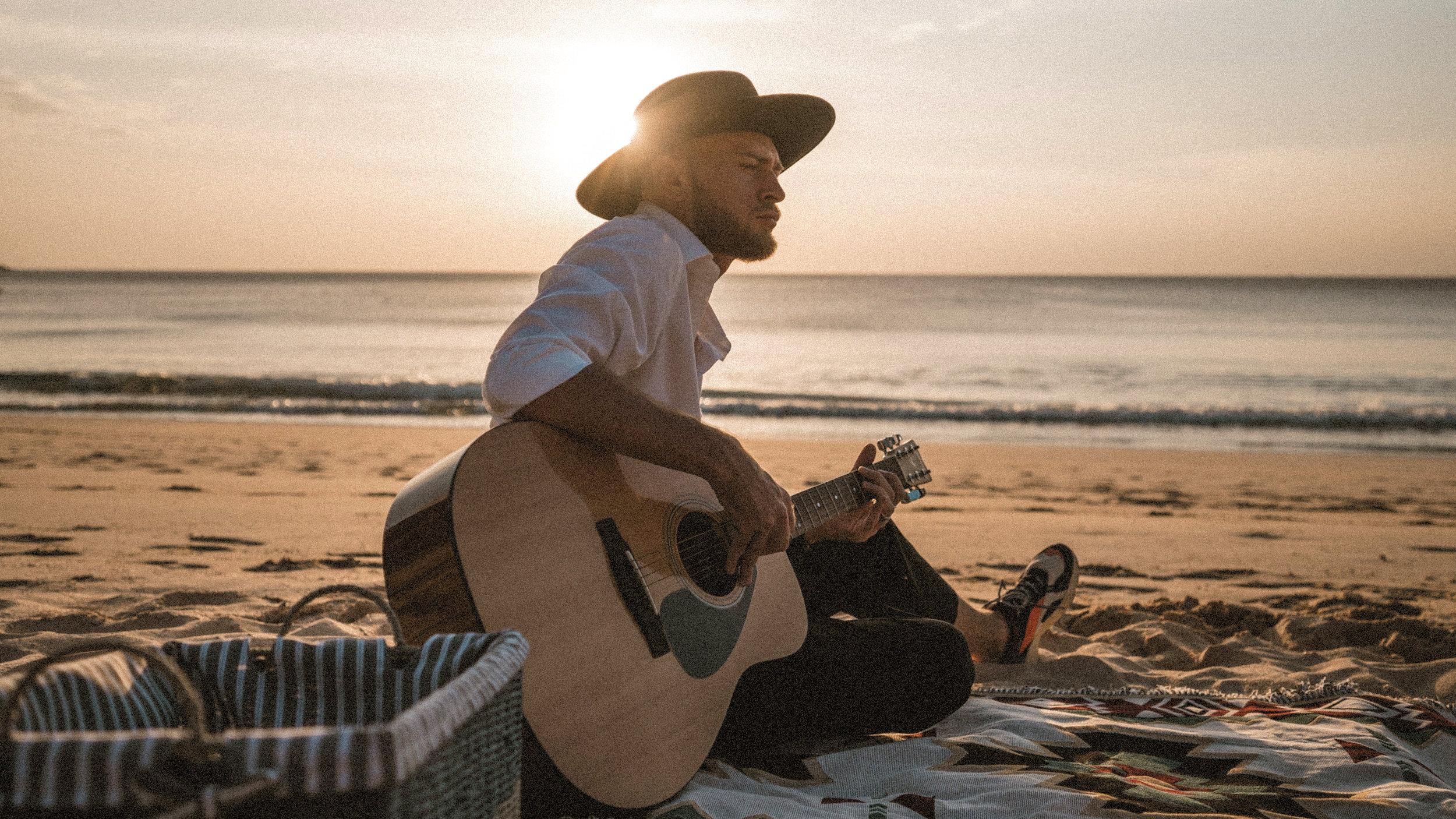 Man guitar beach sunset