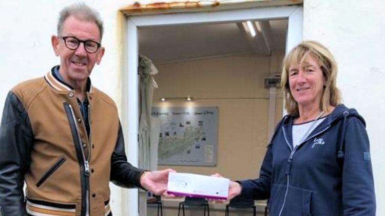 President William Tate receives his lateral flow test pack from the Welcome Teams Candy Osborne
