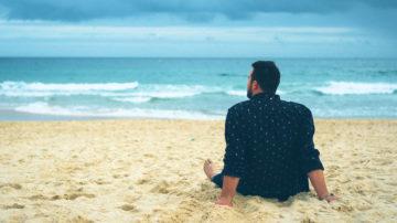 Man sitting on beach lonely