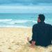 Man sitting on beach lonely